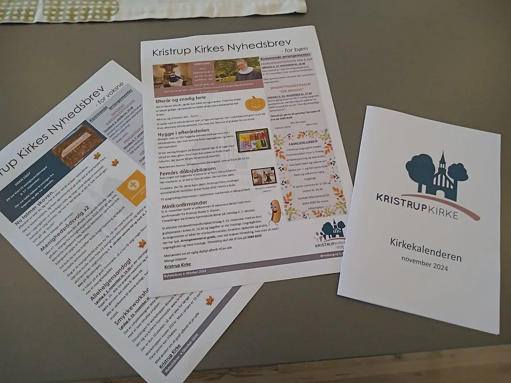 To nyhedsbreve og en folder liggende på et bord