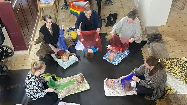 Kvinder legende med deres liggende babyer på kirkegulv