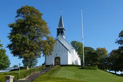 Hvid kirke på grøn bakketop
