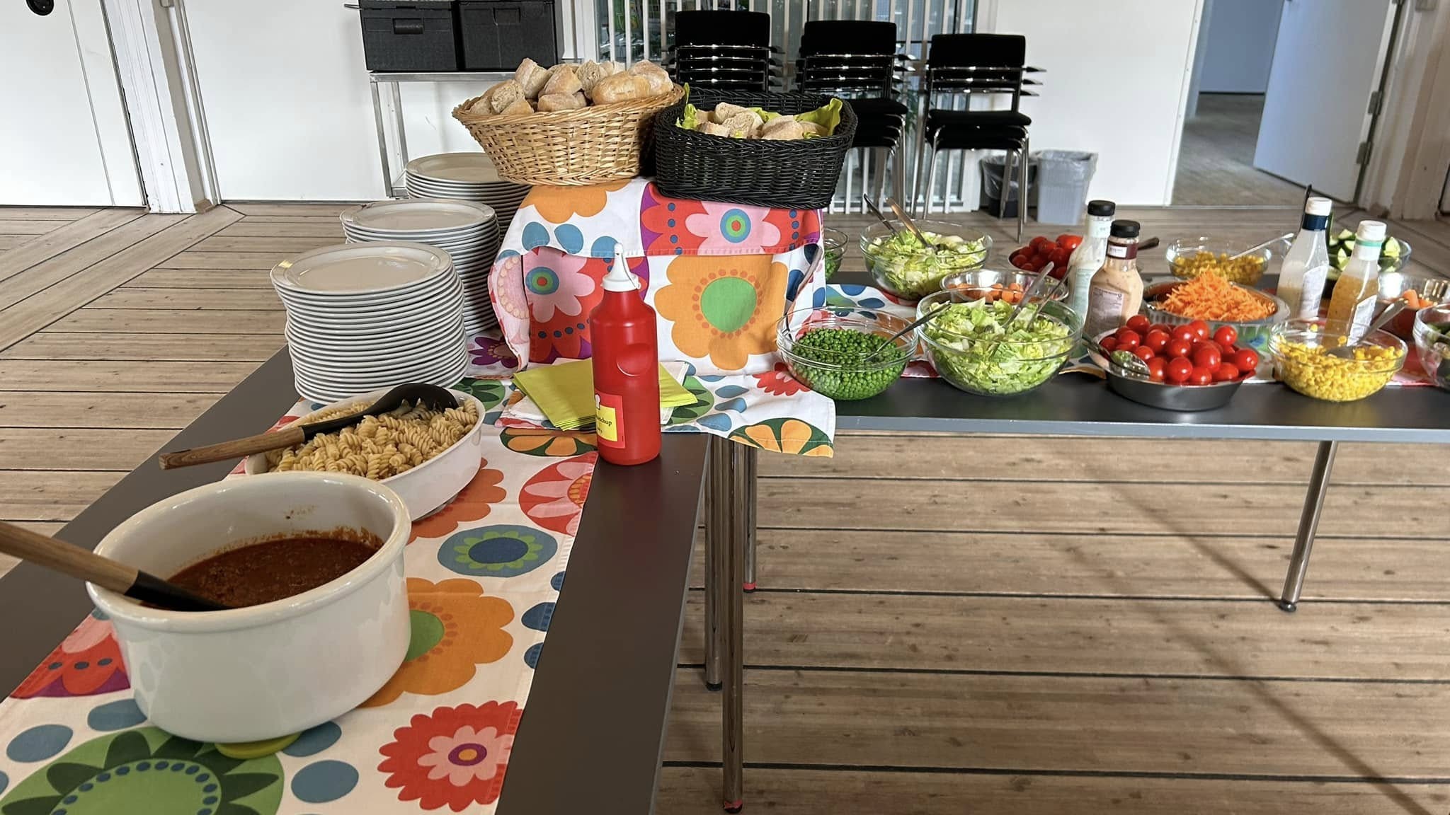 Buffet med spaghetti, kødsauce, brød og grøntsager