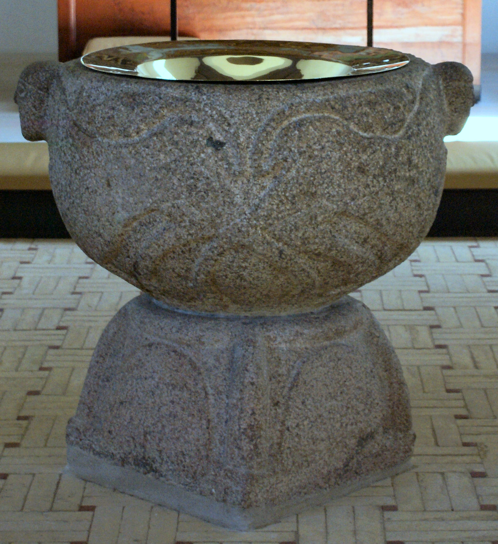 Præst hælder dåbsvand op i dåbsfad